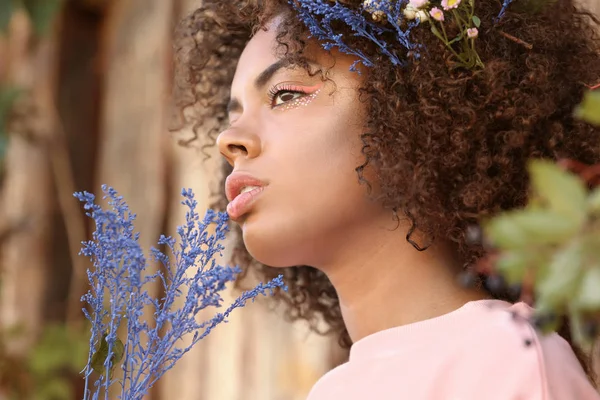 Hermosa joven afroamericana con flores al aire libre —  Fotos de Stock