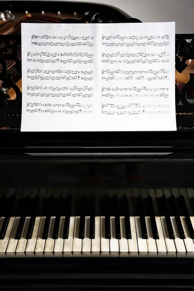 Музичні ноти на чорному піаніно — стокове фото
