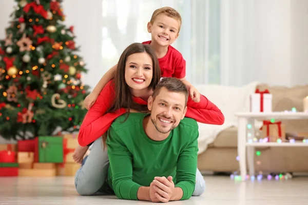 Casal feliz com filho na sala de estar decorado para o Natal — Fotografia de Stock
