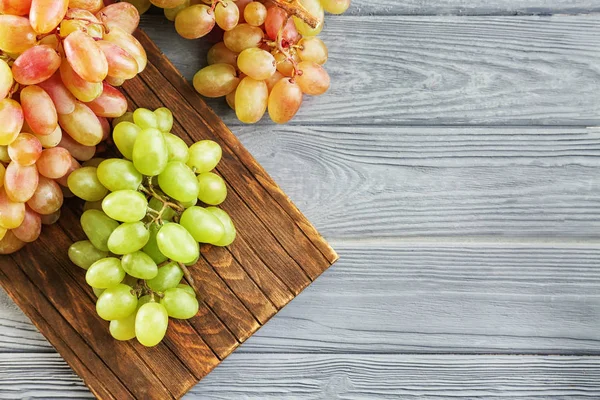 Fresh ripe grapes on wooden board — Stock Photo, Image