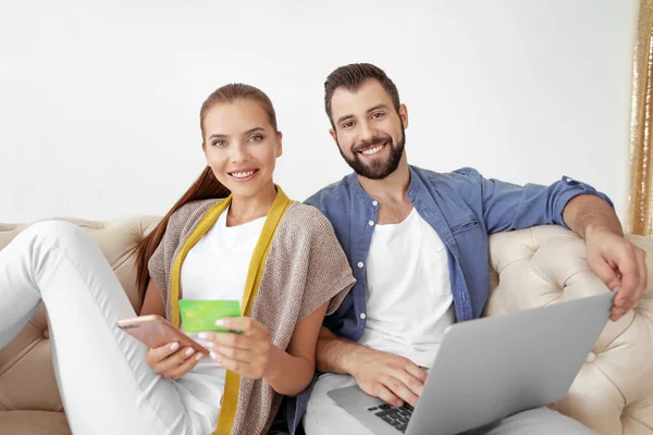Jeune couple avec ordinateur portable et smartphone à la maison. Concept de magasinage Internet — Photo