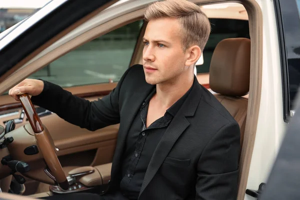 Jonge man op de stoel van de bestuurder van de auto — Stockfoto