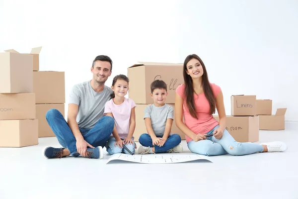 Familia examinando el plan de casa en el piso — Foto de Stock