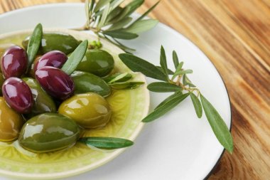 Plaka üzerinde ahşap masa, closeup konserve zeytin ile