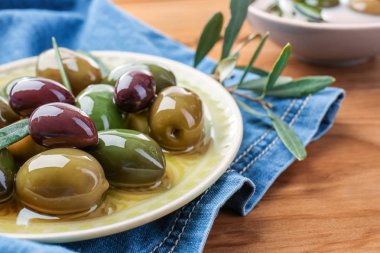 Ahşap masa üzerinde konserve zeytin ile plaka