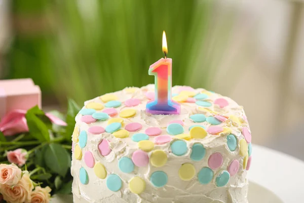 Pastel con vela para el primer cumpleaños sobre fondo borroso — Foto de Stock