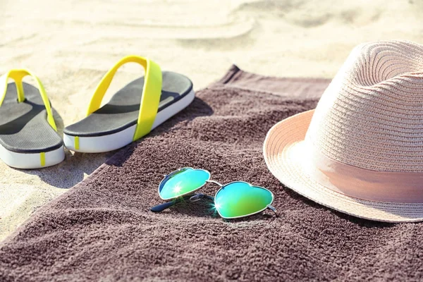 Brown beach towel and summer accessories on sand — Stock Photo, Image