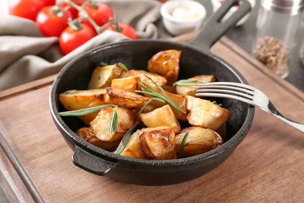 Deliciosas patatas al horno con romero en sartén sobre la mesa — Foto de Stock