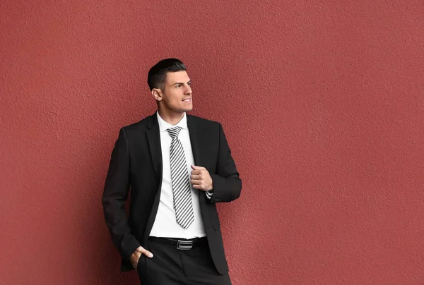 Hombre en traje formal cerca de la pared roja —  Fotos de Stock