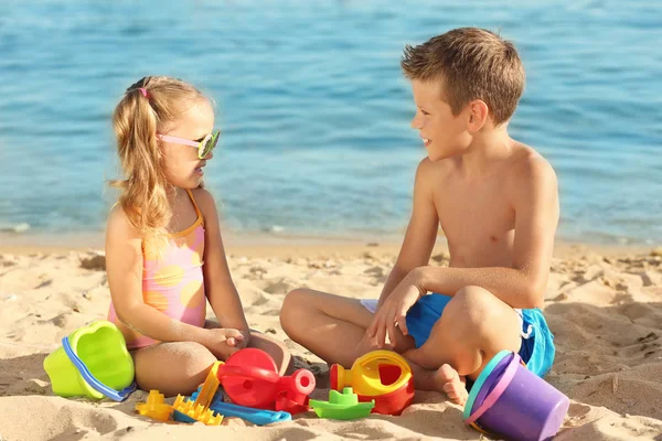 Niedliche kleine Kinder spielen am Meeresstrand — Stockfoto