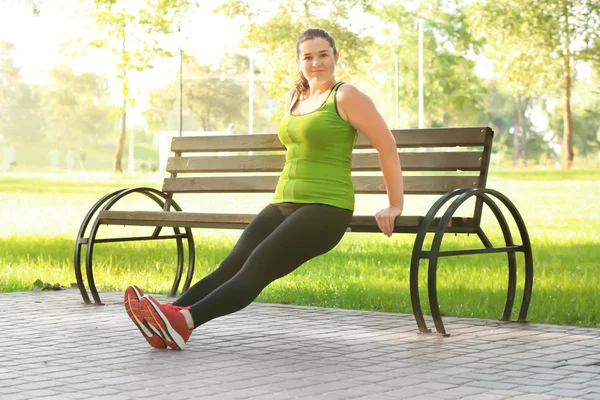 Mujer joven con sobrepeso haciendo ejercicio — Foto de Stock