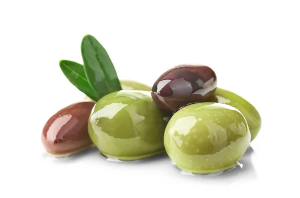 Konzervované olivy s listí na bílém pozadí — Stock fotografie
