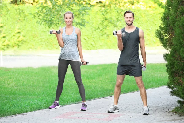 Joven hombre y mujer haciendo ejercicios en el parque — Foto de Stock
