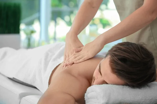 Giovane uomo che fa un massaggio nel salone spa — Foto Stock
