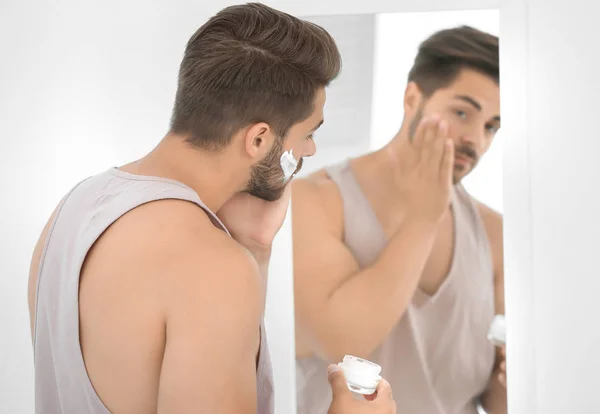 Homem aplicando creme facial — Fotografia de Stock