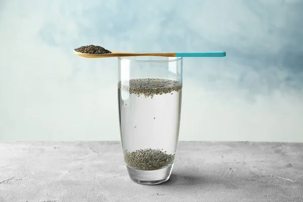 Spoon and glass of water with chia seeds — Stock Photo, Image