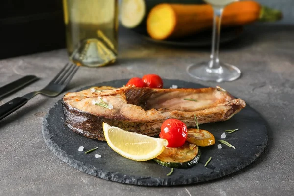 Břidlicové desky s Smažené rybí steak a zeleninu na stole — Stock fotografie