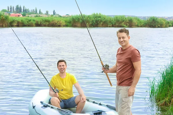 Dos hombres que pescan del barco inflable en río — Foto de Stock