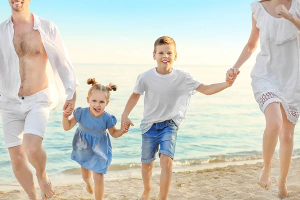 Familia feliz en la playa del mar en el complejo —  Fotos de Stock