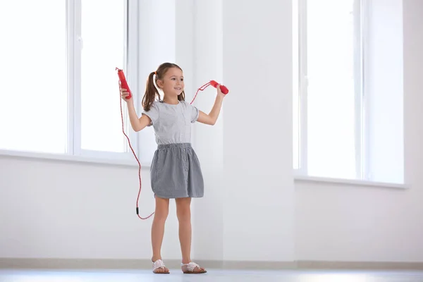 Adorable girl skipping rope indoors — Stock Photo, Image