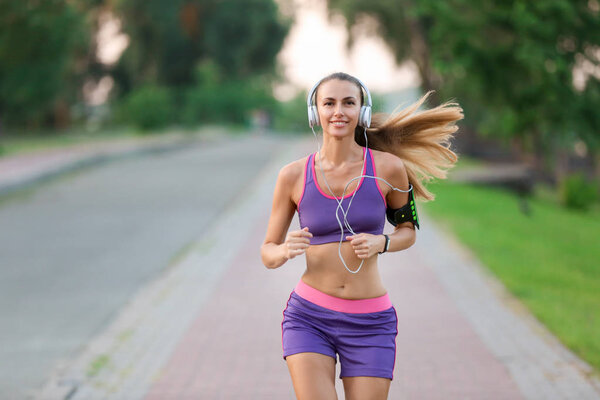 Young sporty woman running in park