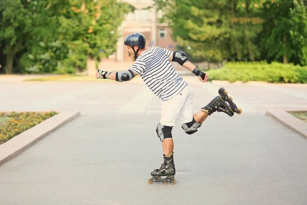 Young man on roller skates in summer park — Stock Photo, Image