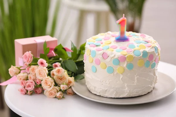 Pastel con vela para el primer cumpleaños en la mesa —  Fotos de Stock