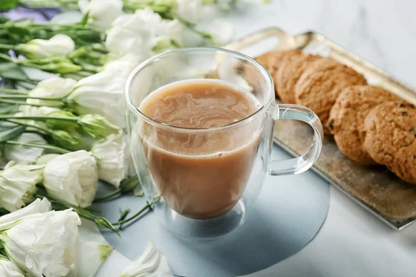 Composición con hermosas flores, taza de café y galletas en la mesa —  Fotos de Stock