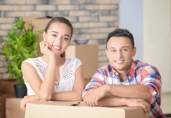 Gelukkige jonge paar met bewegende vak in hun nieuwe appartement — Stockfoto