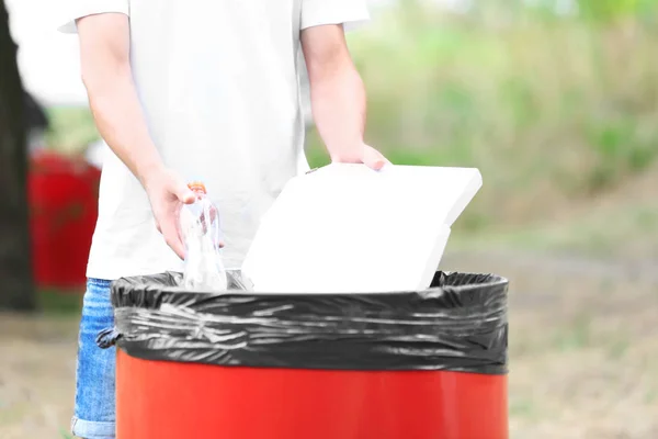 Genç adam açık havada çöp kutusu içine çöp atma — Stok fotoğraf