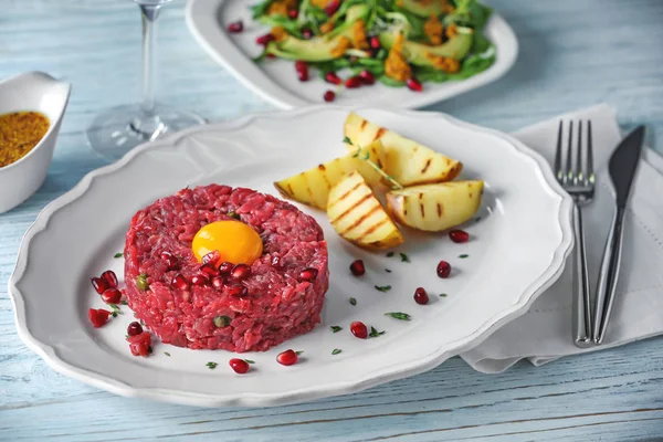 Delicioso tártaro de bistec con yema, semillas de granada y patatas —  Fotos de Stock