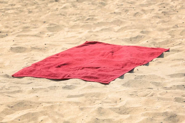 Red beach towel on sand — Stock Photo, Image