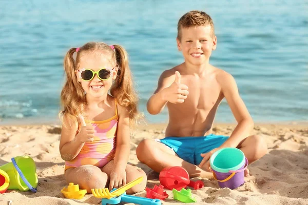 Niedliche kleine Kinder spielen am Meeresstrand — Stockfoto