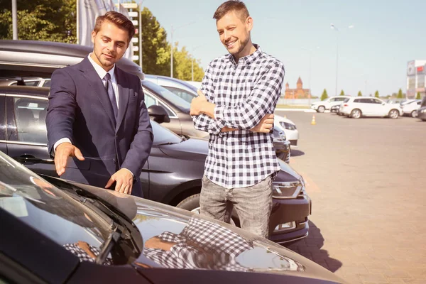 Продавець показує новий автомобіль — стокове фото