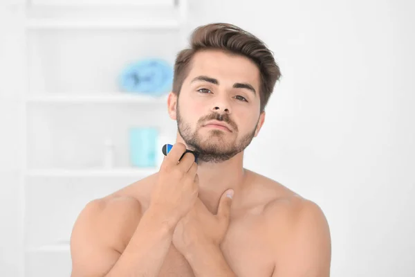 Handsome young man shaving — Stock Photo, Image