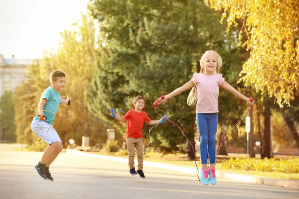 Adorable children skipping rope outdoors — Stock Photo, Image