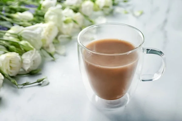 Скляна чашка кави та квітів на столі — стокове фото