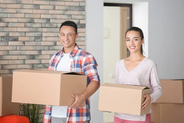 Feliz pareja joven con cajas móviles en su nuevo apartamento — Foto de Stock