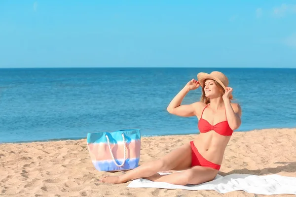 Mujer joven con buen cuerpo tomando el sol en la playa de mar — Foto de Stock