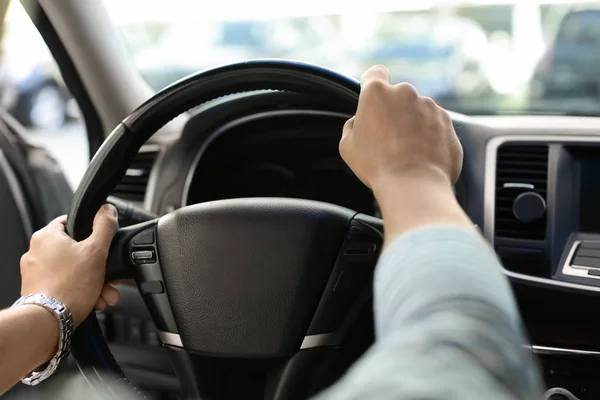 Mãos masculinas no volante de um carro — Fotografia de Stock