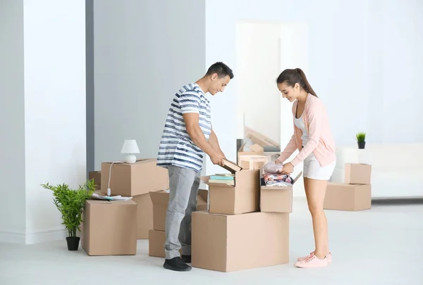 Jong stel uitpakken dozen in hun nieuwe appartement — Stockfoto