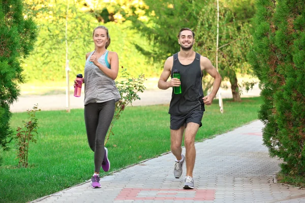 Joven y mujer corriendo en el parque — Foto de Stock