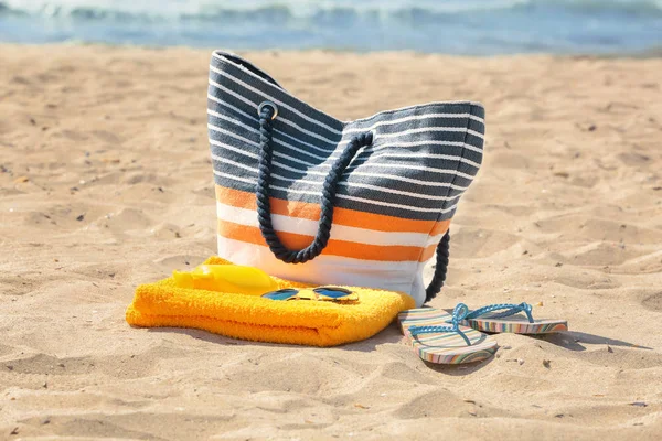 Beach towel with sunglasses and bag on sand — Stock Photo, Image