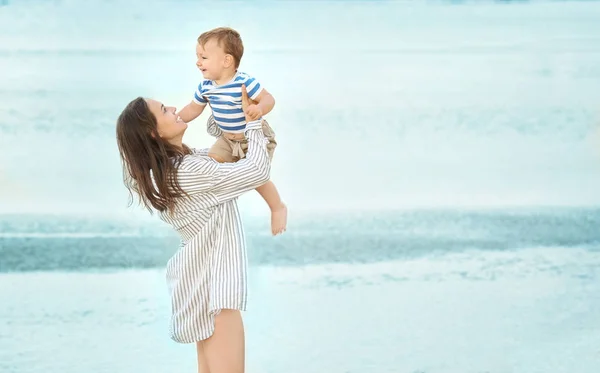 Lycklig mamma med lille son på stranden — Stockfoto