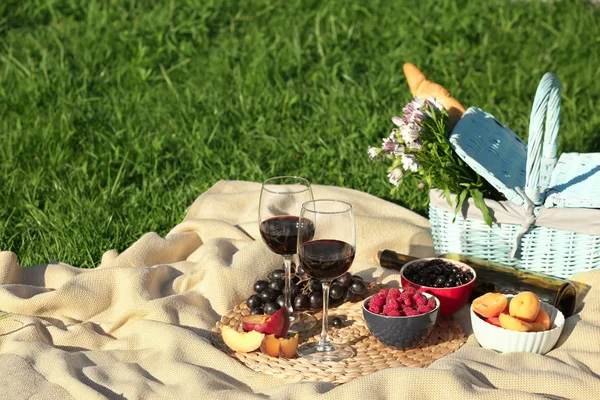 Composition with ripe fruits, wine and picnic basket