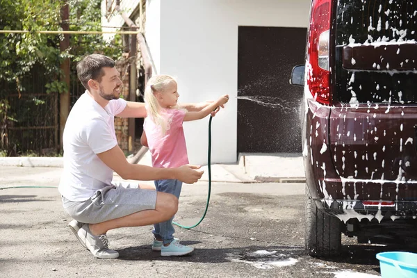Az ember a kis lánya mosás autó szabadban — Stock Fotó