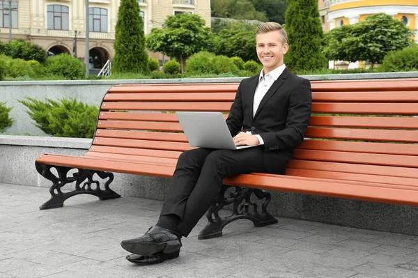Jovem usando laptop, ao ar livre — Fotografia de Stock