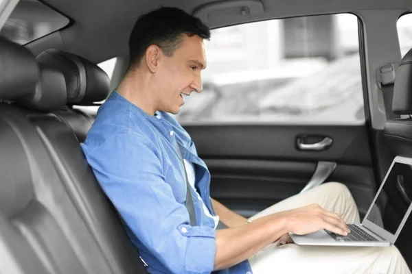 Homem usando laptop no carro — Fotografia de Stock