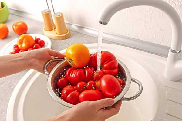 Vrouwelijke handen wassen tomaten — Stockfoto