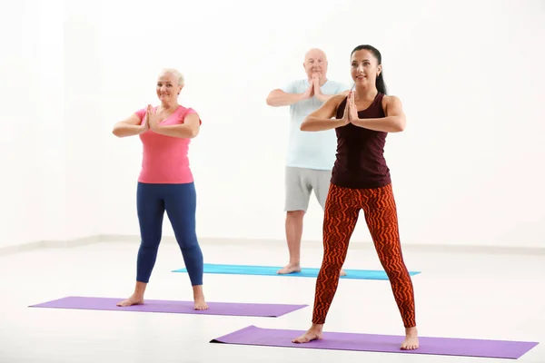 Gruppo di persone mature a lezione di yoga in casa — Foto Stock